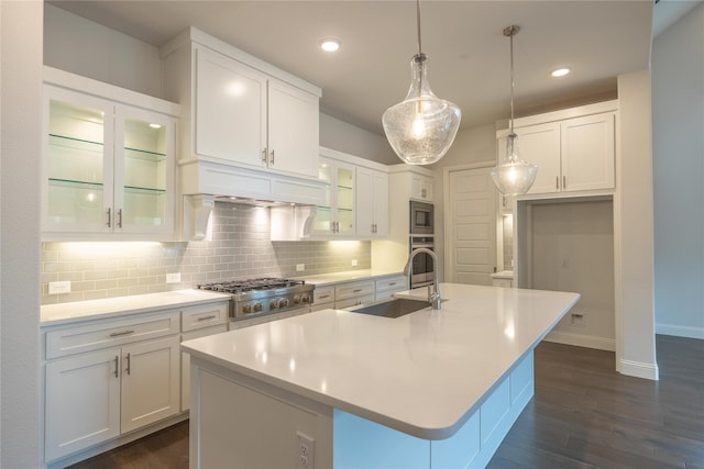 kitchen featuring a sink, backsplash, white cabinetry, appliances with stainless steel finishes, and dark wood-style flooring