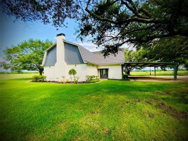 rear view of property featuring a lawn and a carport