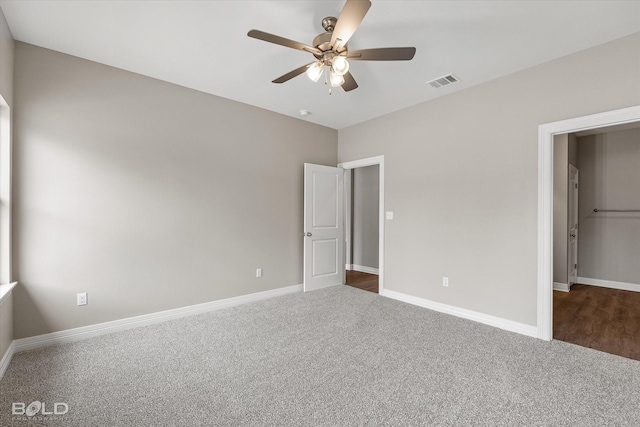 unfurnished bedroom featuring dark colored carpet, visible vents, and baseboards