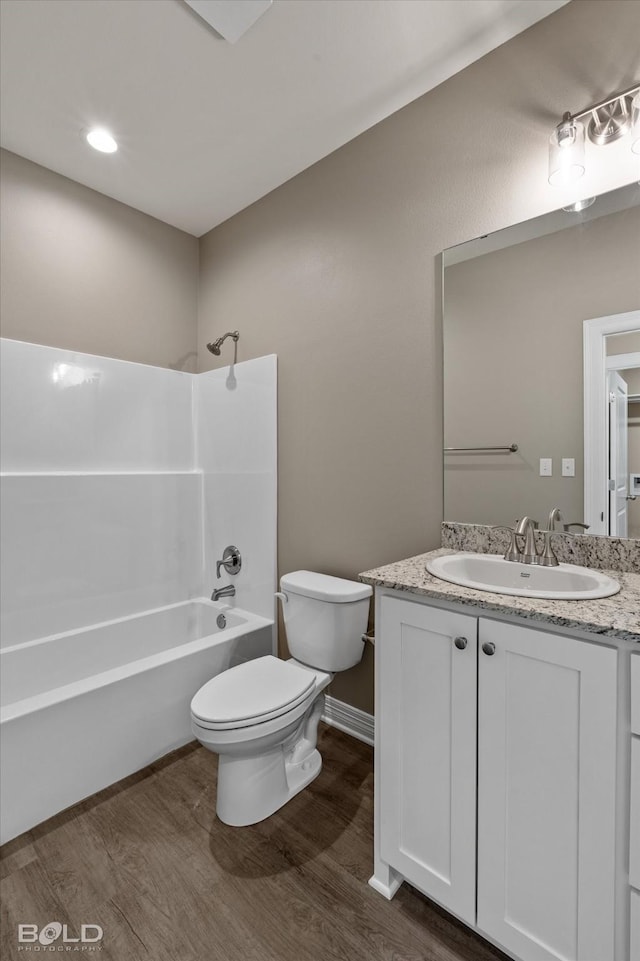 bathroom with toilet, bathtub / shower combination, wood finished floors, and vanity