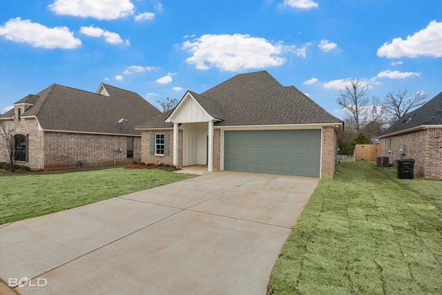 view of front facade with a front yard, concrete driveway, brick siding, and an attached garage