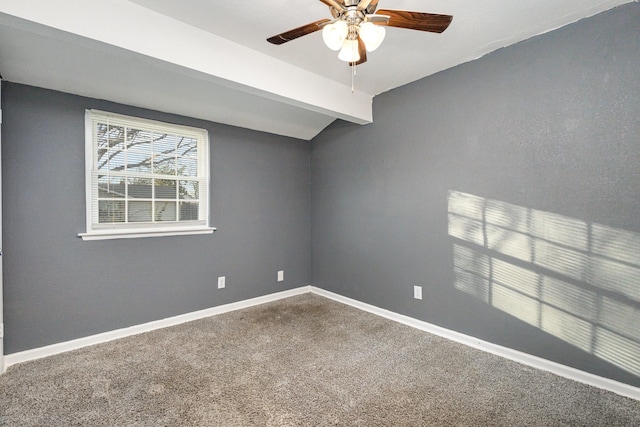 carpeted spare room with ceiling fan and beamed ceiling