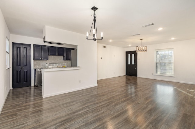 unfurnished living room with dark hardwood / wood-style flooring and an inviting chandelier