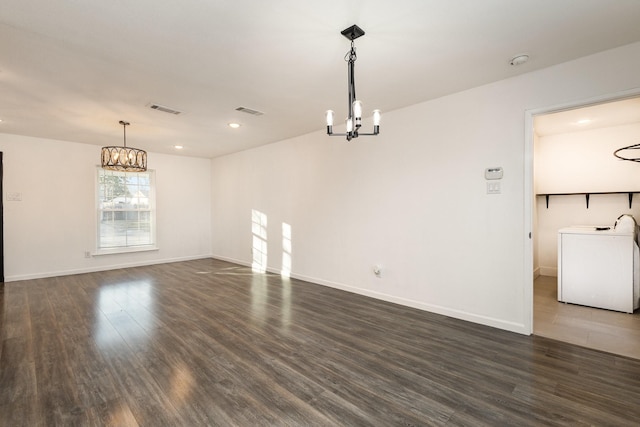 unfurnished living room with dark wood-type flooring and a notable chandelier