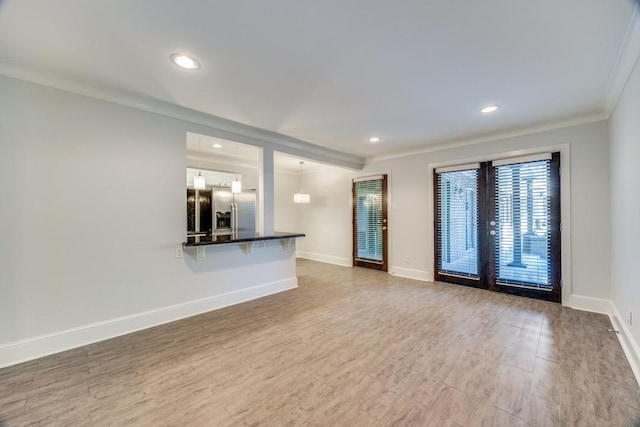 unfurnished living room with hardwood / wood-style floors and ornamental molding