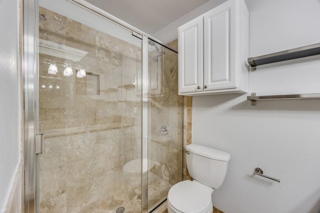 bathroom with toilet and a shower with door