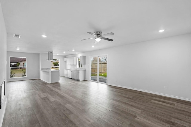 unfurnished living room with ceiling fan and dark hardwood / wood-style flooring