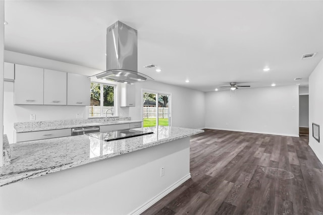 kitchen with light stone countertops, black electric stovetop, stainless steel dishwasher, island range hood, and ceiling fan