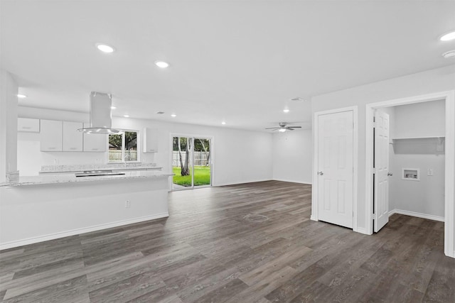 unfurnished living room featuring dark hardwood / wood-style flooring and ceiling fan