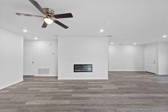 unfurnished living room featuring ceiling fan, light wood-type flooring, and heating unit