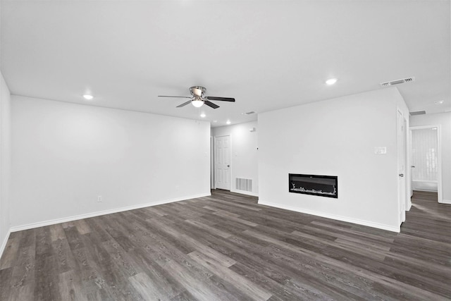 unfurnished living room featuring ceiling fan and dark hardwood / wood-style flooring