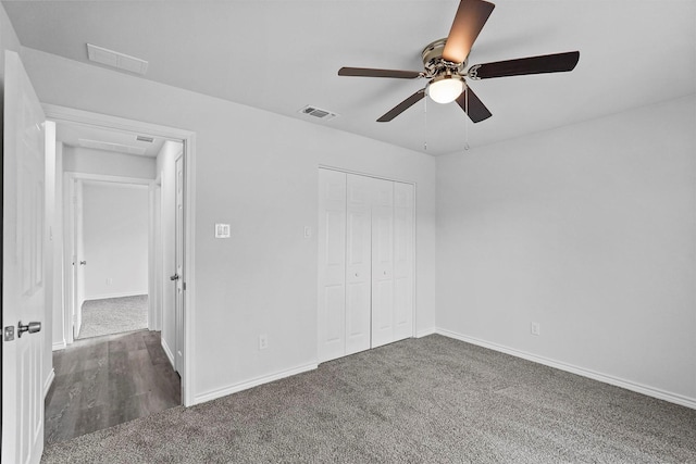 unfurnished bedroom with ceiling fan, dark carpet, and a closet