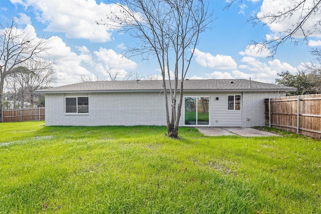 rear view of property featuring a patio and a lawn