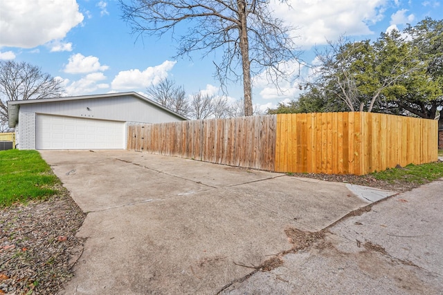 view of yard with a garage and central AC unit