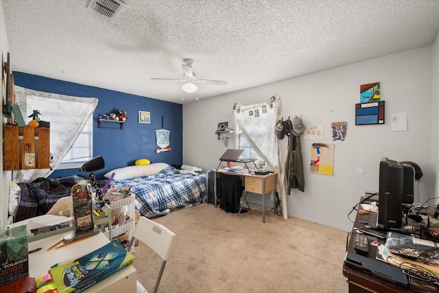 carpeted bedroom with ceiling fan and a textured ceiling