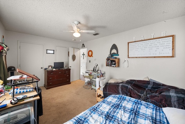 carpeted bedroom featuring a textured ceiling and ceiling fan