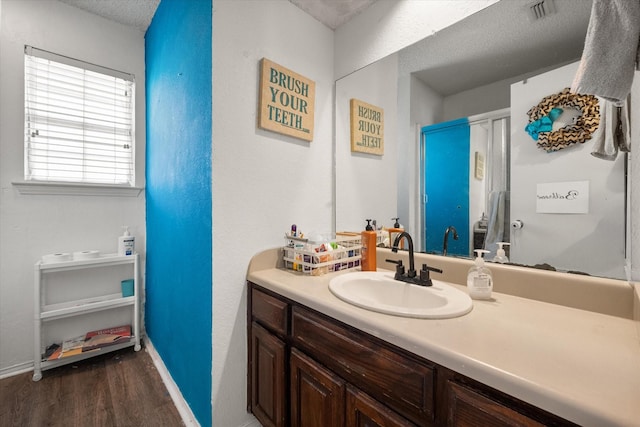 bathroom featuring vanity, wood-type flooring, and a textured ceiling