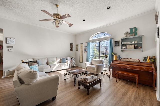 living room featuring hardwood / wood-style floors, a textured ceiling, ceiling fan, and ornamental molding