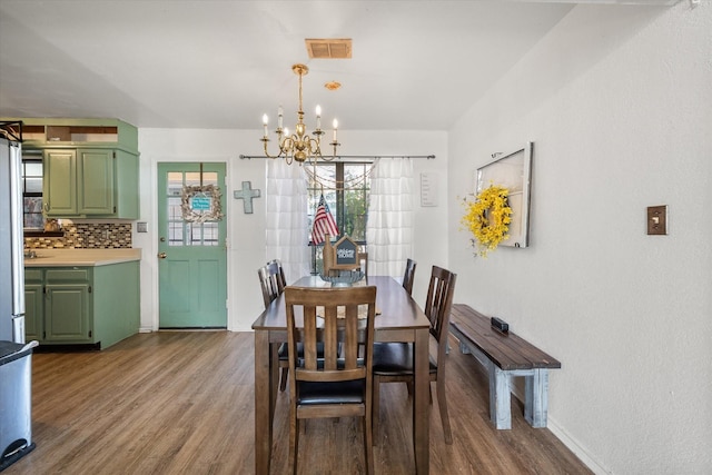 dining room with hardwood / wood-style flooring and a notable chandelier