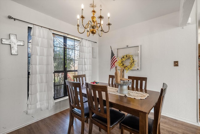 dining space featuring dark hardwood / wood-style flooring and an inviting chandelier