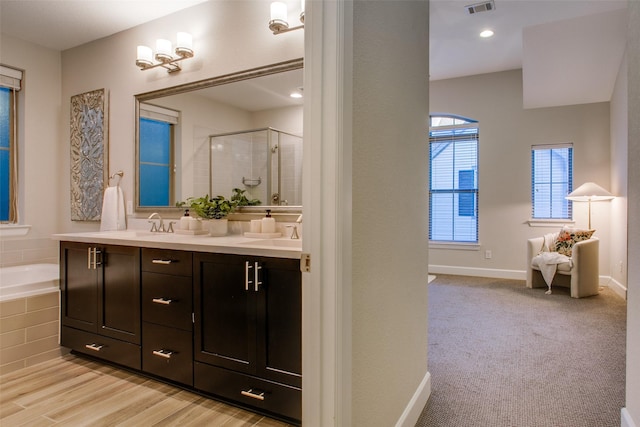 bathroom with vanity, wood-type flooring, and independent shower and bath