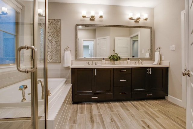 bathroom with tiled tub and vanity