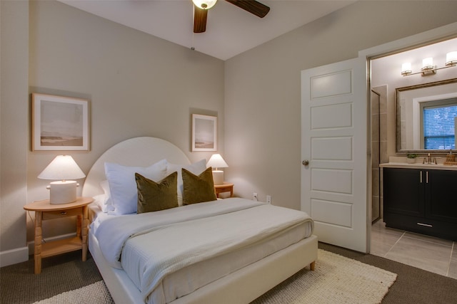 bedroom with ceiling fan, light tile patterned flooring, sink, and ensuite bath