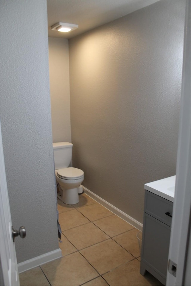 bathroom featuring tile patterned flooring, vanity, and toilet