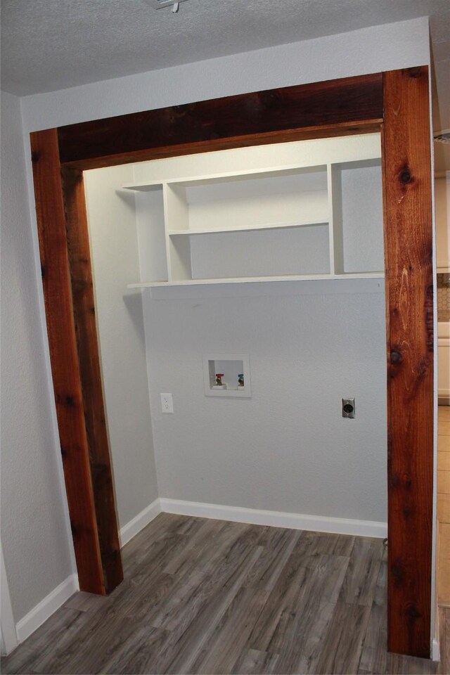 clothes washing area with hookup for a washing machine, dark wood-type flooring, a textured ceiling, and hookup for an electric dryer