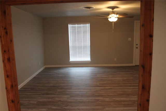 empty room featuring dark hardwood / wood-style flooring and ceiling fan