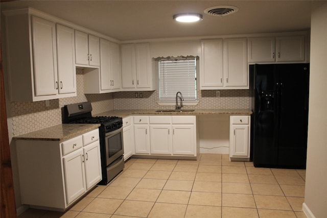 kitchen with gas stove, tasteful backsplash, black fridge with ice dispenser, and sink