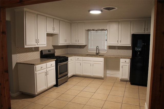 kitchen featuring stainless steel gas range, black fridge with ice dispenser, sink, light tile patterned floors, and white cabinetry