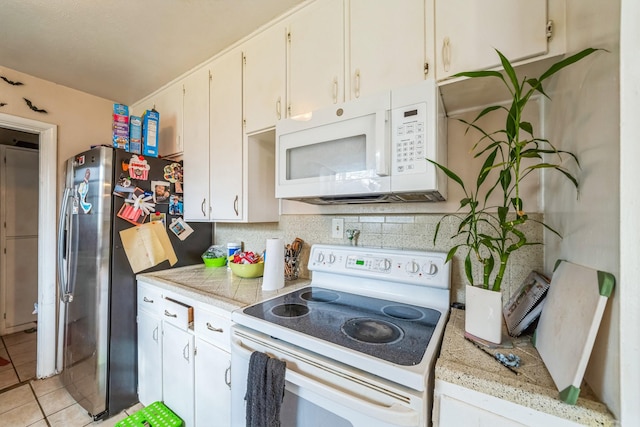 kitchen featuring light tile patterned floors, white appliances, white cabinetry, and backsplash