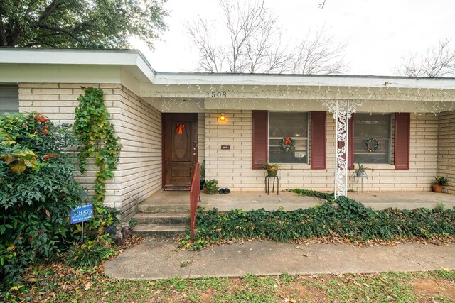 view of exterior entry featuring a porch