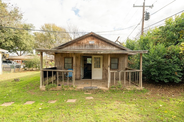 view of outdoor structure featuring a lawn and a porch