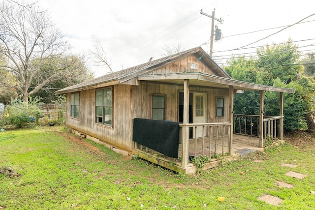 view of side of property with a porch and a yard