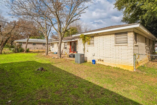 back of house with a lawn and central air condition unit