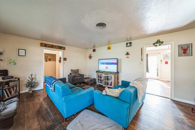 living room featuring a textured ceiling and dark wood-type flooring