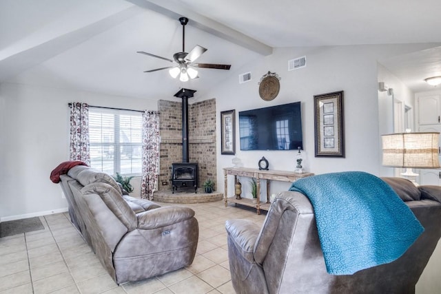 living room with ceiling fan, light tile patterned flooring, vaulted ceiling with beams, and a wood stove