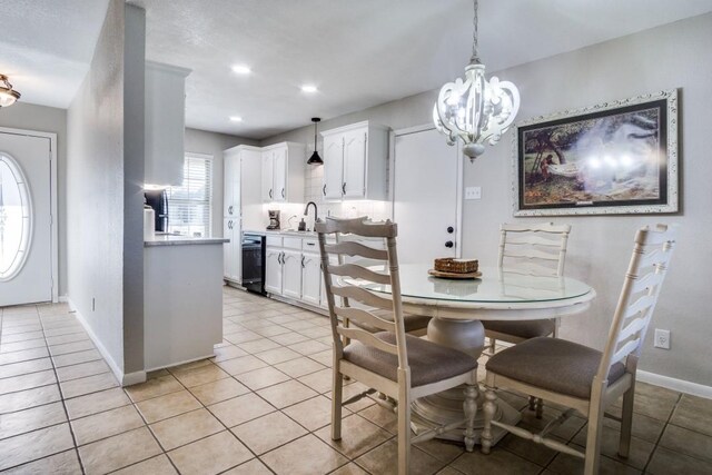 tiled dining space featuring sink and a chandelier