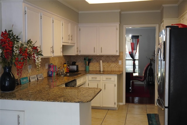 kitchen featuring stone counters, kitchen peninsula, decorative backsplash, white cabinetry, and stainless steel refrigerator