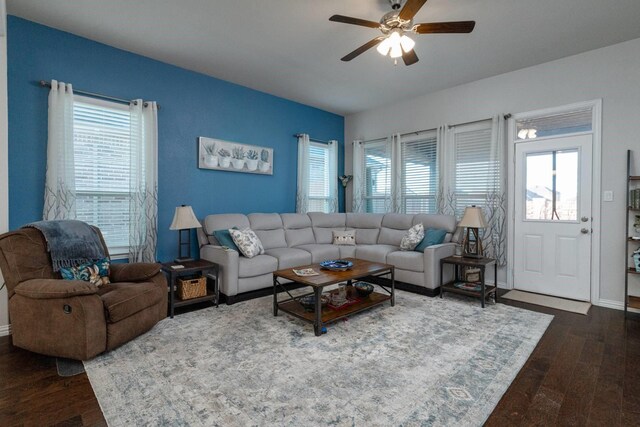 living room featuring ceiling fan and dark wood-type flooring