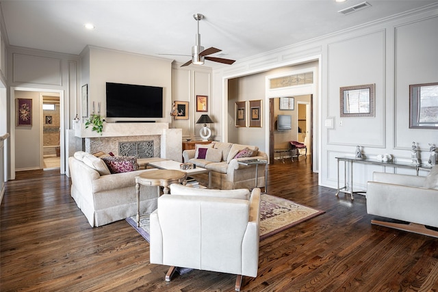 living room with ceiling fan, dark wood-type flooring, and ornamental molding