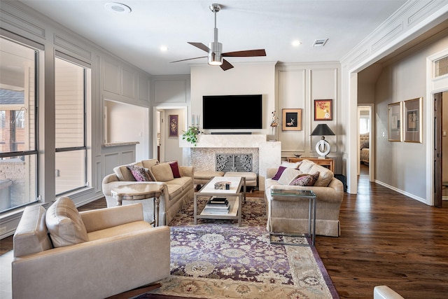 living room featuring dark hardwood / wood-style floors, ceiling fan, and ornamental molding