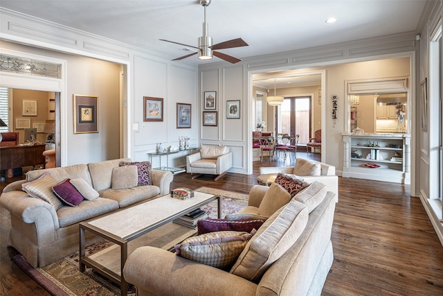 living room featuring ceiling fan, crown molding, and dark wood-type flooring