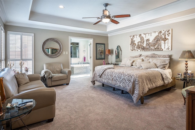 carpeted bedroom featuring ceiling fan, ensuite bath, ornamental molding, and a tray ceiling