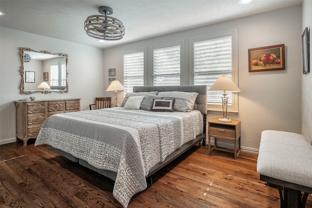 bedroom featuring a notable chandelier, dark hardwood / wood-style floors, and multiple windows