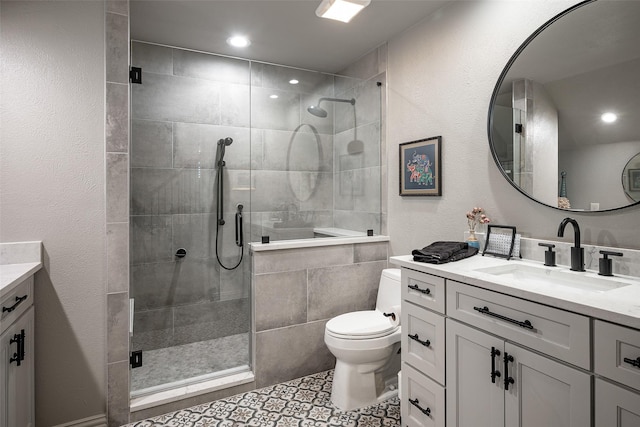 bathroom with toilet, vanity, tile patterned floors, and a shower with shower door