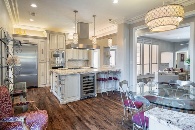 kitchen featuring wine cooler, light stone counters, island exhaust hood, built in appliances, and pendant lighting