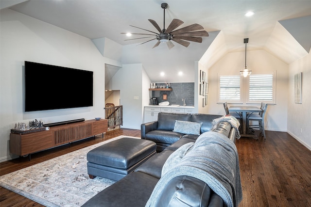 living room with dark hardwood / wood-style floors, ceiling fan, sink, and vaulted ceiling